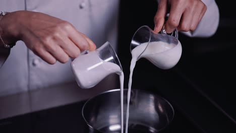Koch-Gießt-Zwei-Tassen-Frische-Milch-In-Einen-Rostfreien-Topf---Zeitlupe
