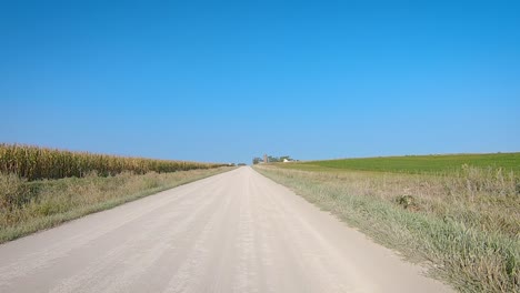 POV-while-driving-past-fields-on-a-wide-gravel-road-in-rural-Iowa-in-late-summer