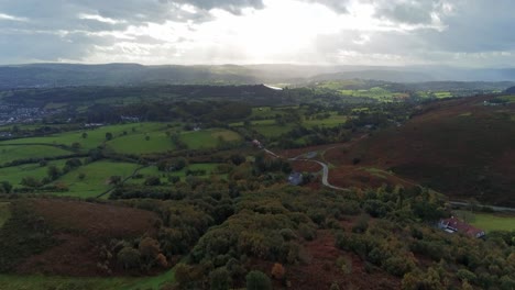 Sunrays-moving-across-rural-English-farmland-countryside-early-dawn-aerial-view-rising-forward