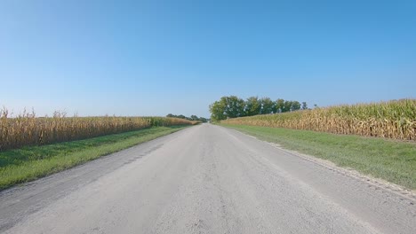 Pov-Mientras-Conduce-Por-Una-Carretera-Pavimentada-Del-Condado-En-La-Zona-Rural-De-Iowa-A-Fines-Del-Verano