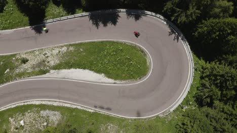 Aerial-top-down-of-a-cyclist-on-a-Hairpin-turn-road,-Dolomites,-Italy