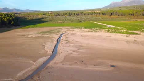 Luftaufnahme-Eines-Schmalen-Flusses,-Der-In-Einen-See-Im-Süden-Spaniens-Mündet