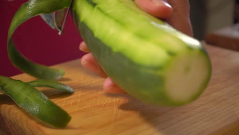 Peeling-a-cucumber-on-a-cutting-board