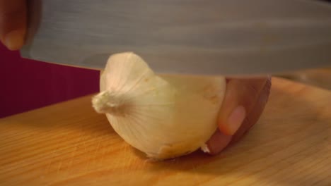 Peeling-a-white-onion-on-a-cutting-board