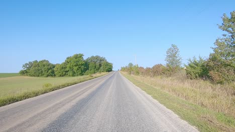 Pov-Mientras-Conduce-Por-Una-Carretera-Pavimentada-Del-Condado-En-La-Zona-Rural-De-Iowa-A-Principios-De-Otoño