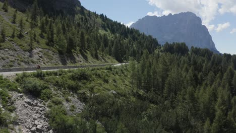 Cyclist-high-speed-on-a-beautiful-road-in-the-green-nature-mountain-area,-Italy