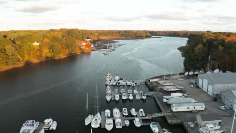 Flying-over-boatyard-with-several-boats-on-Royal-River-at-sunset