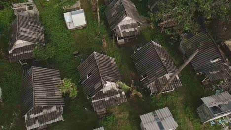 Aerial-sideways-dolly-of-broken-bungalow-rooftops-at-a-abandoned-and-derelict-beach-bungalow-tourist-resort-in-Koh-Chang-Thailand-due-to-the-effect-of-covid-on-global-travel-and-tourism