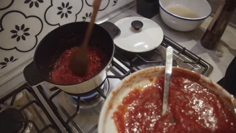 Mischen-Von-Frischer-Tomatensauce-Mit-Gebratenen-Tomatenwürfeln-Im-Heißen-Kochtopf-Auf-Dem-Gasherd