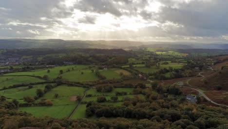 Sunrays-moving-across-rural-English-farmland-countryside-early-dawn-aerial-descending-view