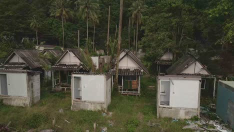 Aerial-birds-eye-view-reveal-shot-of-a-abandoned-and-derelict-beach-bungalow-tourist-resort-in-Koh-Chang-Thailand-due-to-the-effect-of-covid-on-global-travel-and-tourism
