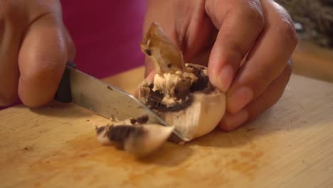 Mushroom-sliced-with-a-small-knife-on-a-cutting-board