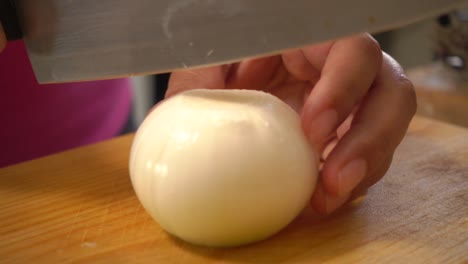 A-white-onion-cut-in-half-then-sliced-on-a-cutting-board