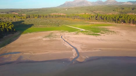 Luftbild-Eines-Flusses,-Der-In-Einem-Dürregebiet-In-Andalusien,-Spanien,-In-Einen-See-Mündet