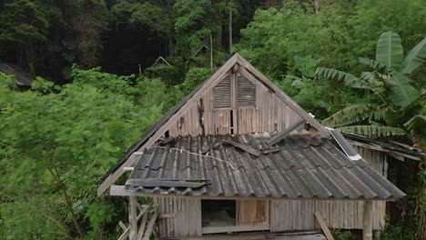 dolly-shot-droneflyes-closely-over-old-style-wooden-Thai-bungalow-that-is-now-derelict-and-unused-due-to-the-effects-of-the-pandemic-on-travel-and-tourism