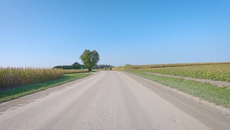 Double-time-POV-while-driving-on-a-gravel-country-road-in-rural-Iowa-in-early-autumn
