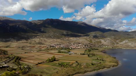 Vista-Panorámica-Del-Campo-Con-Pueblos-A-Orillas-Del-Lago-De-Montaña-En-Prespa,-Albania