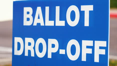 Blaues-Wahlzettel-Abgabeschild,-Das-Draußen-Im-Wind-Aus-Nächster-Nähe-Weht