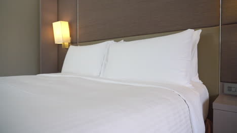 Sauberes-Hotelzimmer-Mit-Frischem-Weißen-Bettlaken-Und-Kissen-In-Einem-Leeren-Raum