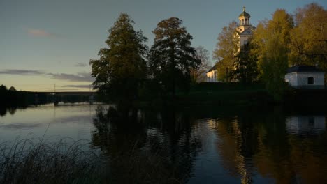 A-white-church-with-reflection-in-the-calm-water-in-sunset-light