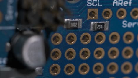 Close-up-of-pin-ports-and-capacitors-on-a-electronic-circuit-board