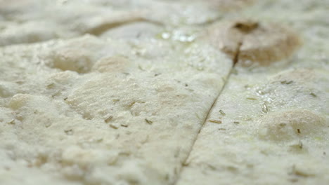 Close-up-shot-of-authentic-Italian-starter-schiacciata-with-virgin-olive-oil-and-oregano