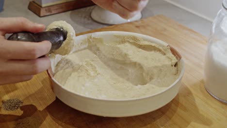Kichererbsen-Von-Hand-Zu-Hummus-Auf-Holztisch-In-Der-Küche-Pürieren