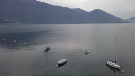 Aerial-forward-over-moored-boats-on-Maggiore-Lake-near-Ascona-town