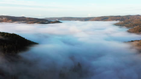 Thick-Fog-Blanketing-Woodland-Foothill-Mountains,-Aerial-Birds-Eye-View