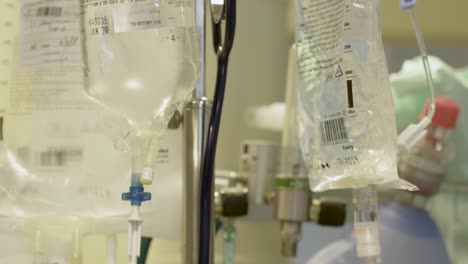 Several-Intravenous-Fluid-Bags-Hanging-On-The-Intravenous-Pole-Next-To-Oxygen-Tank-In-A-Patient's-Room-In-The-Hospital