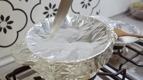 Cutting-holes-inside-foil-paper-cover-on-top-of-pot-with-indian-biriyani-rice-cooking-inside-it