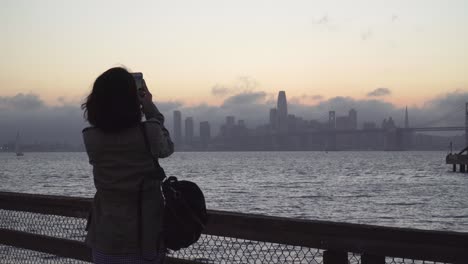 Junge-Frauen,-Die-Ein-Foto-Von-San-Francisco-An-Einem-Friedlichen-Abend-An-Der-Bucht-Machen