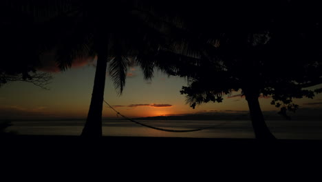 Ein-Entspannender-Sonnenuntergang-Auf-Einer-Tropischen-Insel-Mit-Einer-Hängematte-Und-Einigen-Kokospalmen-In-Der-Szene