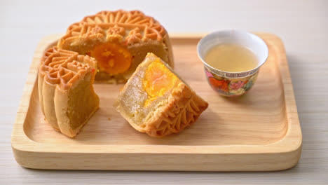 Chinese-moon-cake-durian-and-egg-yolk-flavour-with-tea-on-wood-plate