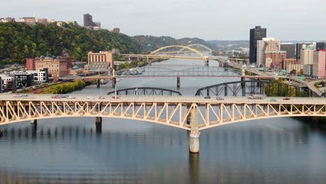 Aerial-tilt-up-reveals-bridges-and-traffic-across-Monongahela-River-in-Pittsburgh,-PA,-USA