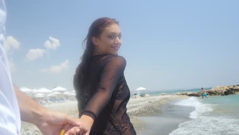 Follow-me,-point-of-view-of-a-beautiful-woman-in-black-holding-hands-and-leading-you-down-a-tropical-beach