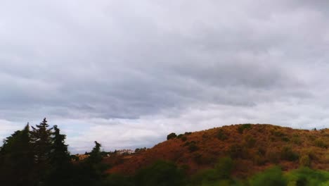 Time-lapse-of-dark-clouds-passing-by-a-hill