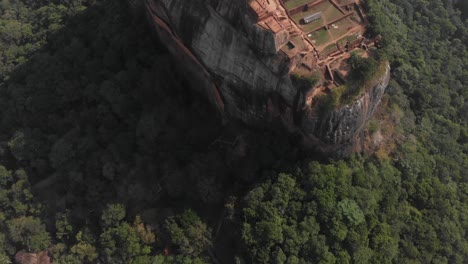 Tilt-up-drone-shot-the-amazing-Lion-Rock-in-Sigiriya,-Sri-Lanka