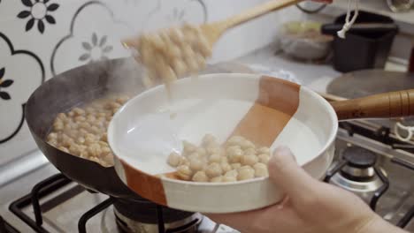 Putting-out-cooked-chickpeas-from-boiling-pan-into-the-plate