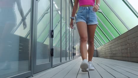 A-young-woman-walking-down-a-trendy-covered-boardwalk-towards-camera
