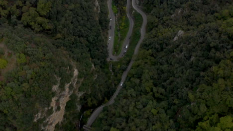 Birds-eye-view-aerial-shot-of-twisty-mountain-road-located-on-banks-of-Lake-Garda,-Italy