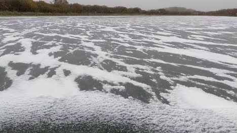 Cold-blowing-snow-accumulating-along-cracks-in-ice-as-the-water-freezes