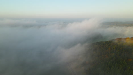 Clouds-rolling-over-the-beautiful-forest-of-Napromek,-Poland--aerial