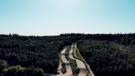 Aerial-view-overlooking-woodland-downhill-freestyle-cycling-dirt-freeride-jumps-in-forest-route