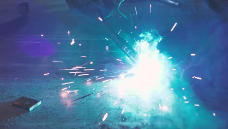 Close-up-work-with-metal-steel-and-iron-using-a-welding-machine,-bright-sparks-and-flashes-in-very-slow-motion