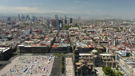 Zocalo-in-Mexico-City,-Birds-Eye-View,-Skyscrapers-in-Background,-Truck-Right