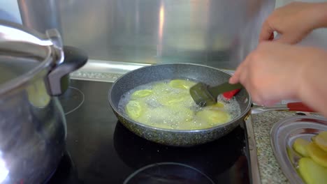 Deep-Frying-Sliced-Potatoes-In-A-Pan-With-Cooking-Oil---close-up