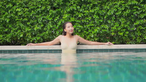Girl-in-Bathing-Suit-Standing-in-Swimming-Pool,-Exterior,-Slow-Motion