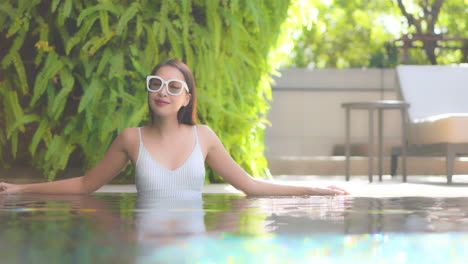 Young-Classy-Petite-Asian-Woman-Standing-in-Water-of-Swimming-Pool-on-a-Hot-Day