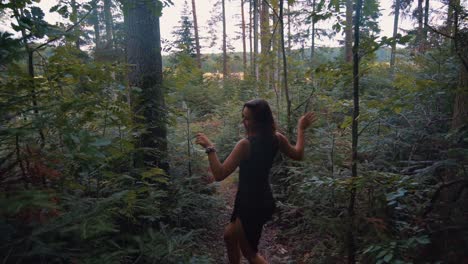 Backward-moving-follow-up-shot-of-young-happy-beautiful-girl-grooving,-dancing-and-enjoying-her-holiday-in-wilderness